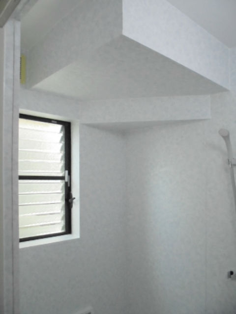 天井の形状に合わせてパネルとシートを巧みに使った階段下の浴室イメージ