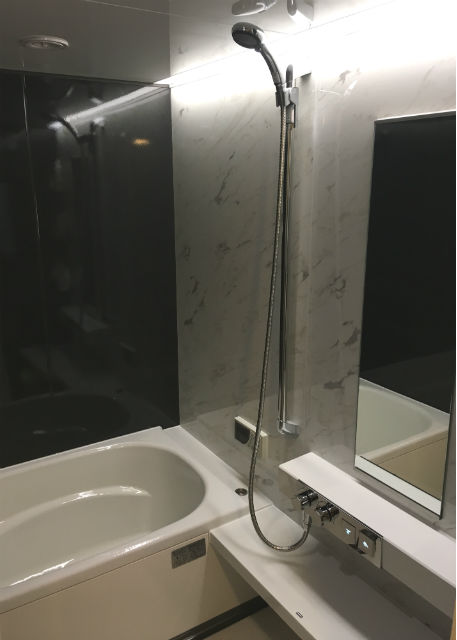 ライン照明が引き立つモノトーンの浴室イメージ