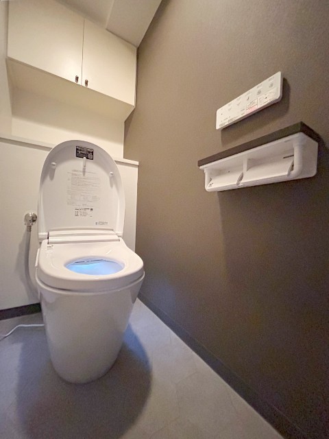 ダークブラウンのアクセントクロスとスマートな形状のトイレ“サティス”施工後イメージ１