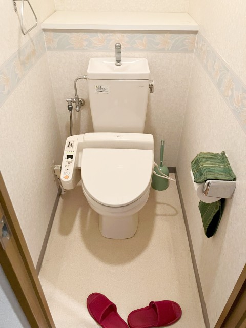 ダークブラウンのアクセントクロスとスマートな形状のトイレ“サティス”施工後イメージ１