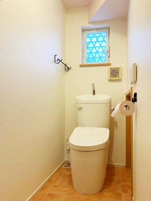 小花柄クロスとテラコッタタイルの床で内装にこだわったトイレ空間イメージ