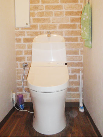 デザイン性のある節水型トイレにレンガ調のクロスでオシャレな空間にイメージ